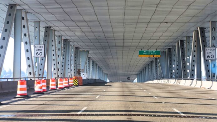 Vista de los carriles exprés de la I-5 sobre el Ship Canal Bridge en Seattle, con barriles de construcción que restringen parte de la vía.
