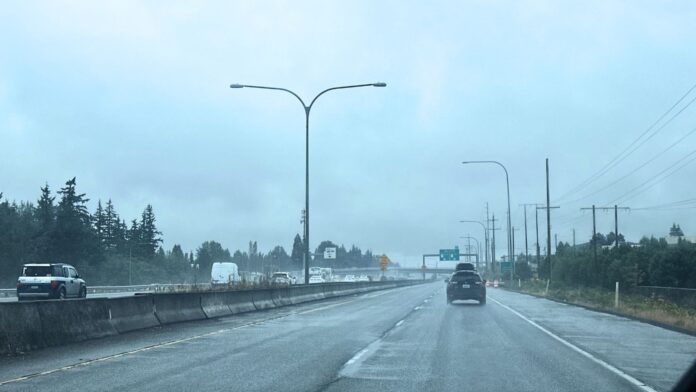 Tormenta Vehículos circulan bajo la lluvia por una autopista mojada en Lynnwood WA durante el paso de una tormenta en la región del Puget Sound.