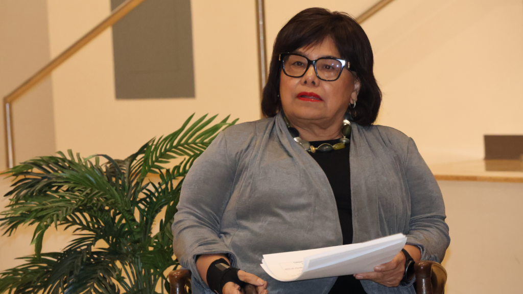 Estela Ortega, directora ejecutiva de El Centro de la Raza, sostiene documentos mientras participa en un panel comunitario sobre las elecciones del Condado de King.