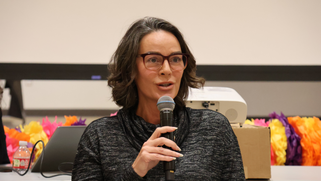 Julie Wise, directora de Elecciones del Condado de King, habla por un micrófono durante un encuentro comunitario sobre seguridad electoral en Seattle.