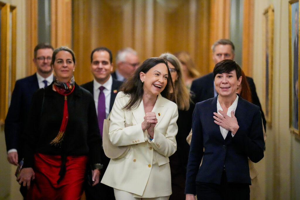 María Corina Machado, ganadora del Premio Nobel de la Paz 2025, sonríe mientras camina junto a Ine Marie Eriksen Søreide por un pasillo del Storting, el Parlamento de Noruega, en Oslo, el 11 de diciembre de 2025.