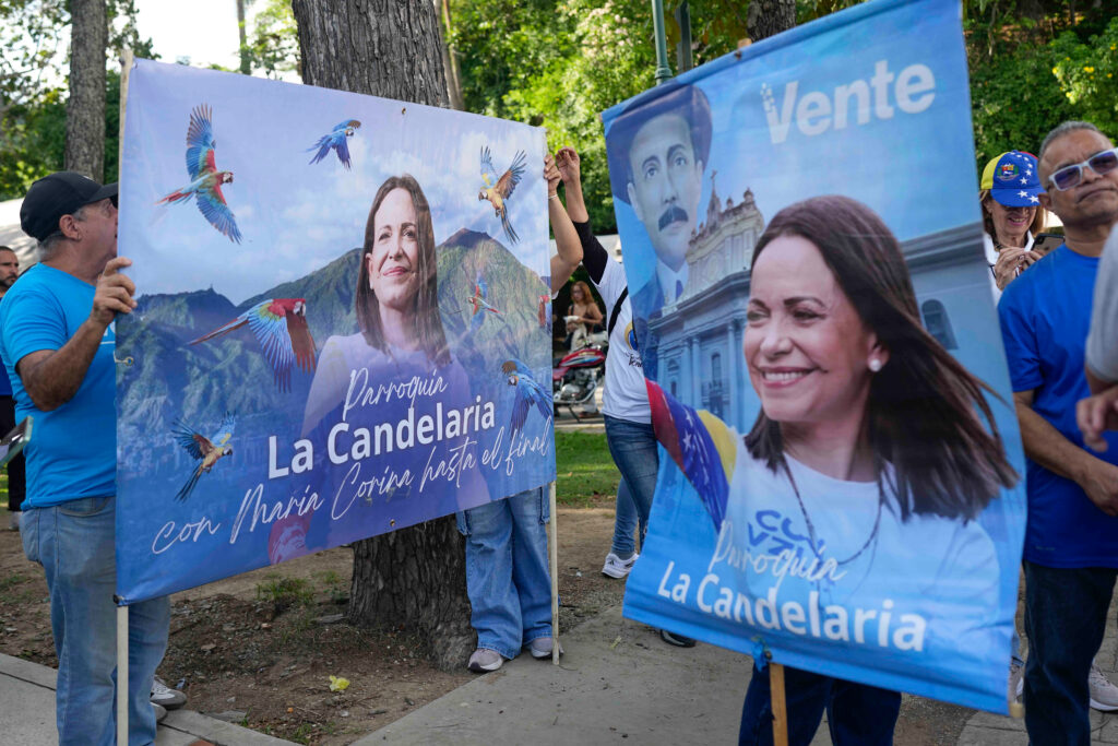 Partidarios de María Corina Machado sostienen grandes pancartas con su imagen y mensajes de apoyo durante una concentración en Caracas, Venezuela, para exigir que se establezca una fecha para las elecciones presidenciales.