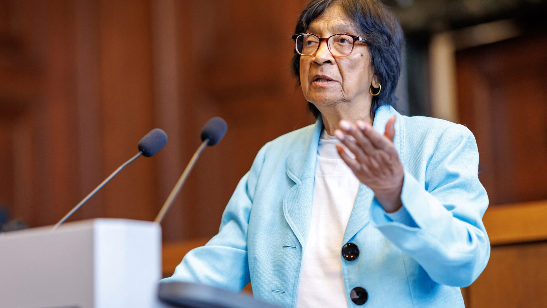 Navi Pillay, jurista sudafricana y ganadora del Premio Nobel de la Paz 2026, habla ante dos micrófonos durante el Foro de Núremberg, Alemania, vestida con una chaqueta azul claro.