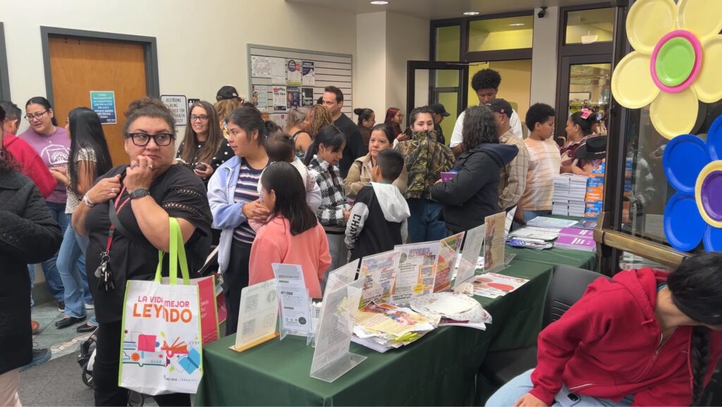 Familias y asistentes recorren mesas con información y recursos comunitarios durante la celebración del Mes de la Herencia Hispana en Lynnwood Library.