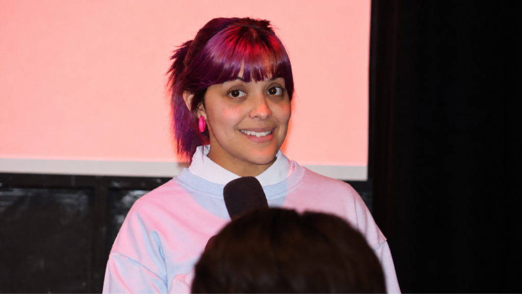 Nari Fateha, integrante de la junta directiva del Seattle Latino Film Festival, sostiene un micrófono durante una conversación con el público en el Central Cinema de Seattle.