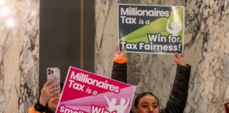 ¿Sabes como funciona el impuesto a los millonarios en WA? Aquí te lo explicamos Dos mujeres sostienen carteles a favor del impuesto a los millonarios durante un evento en el Capitolio estatal de Washington, en Olympia.