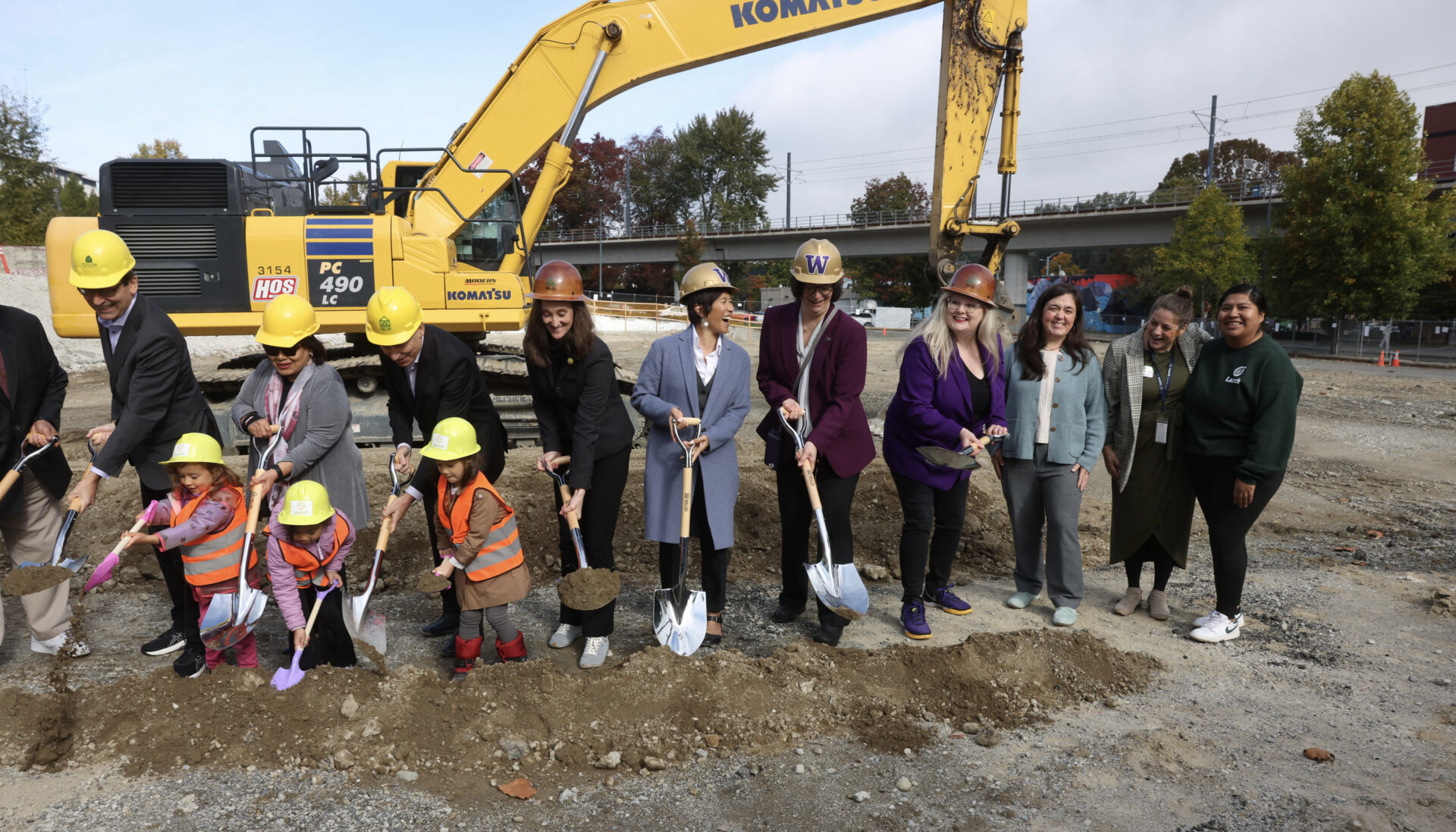 La alcaldesa de Seattle, Katie Wilson, el gobernador de Washington, Bob Ferguson, y Estela Ortega, directora ejecutiva de El Centro de la Raza, participan junto a niños y otros representantes comunitarios en la ceremonia de inicio de construcción del proyecto de viviendas asequibles Mount Baker, en Seattle.