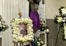 Sacerdote fallece tras caerle un crucifijo mientras celebraba una misa en Ecuador Fotografía del sacerdote Patricio Alfredo Sánchez Molinari rodeada por una corona de flores blancas, frente a un crucifijo con una tela morada y varios arreglos florales en una iglesia de Guayaquil, Ecuador.